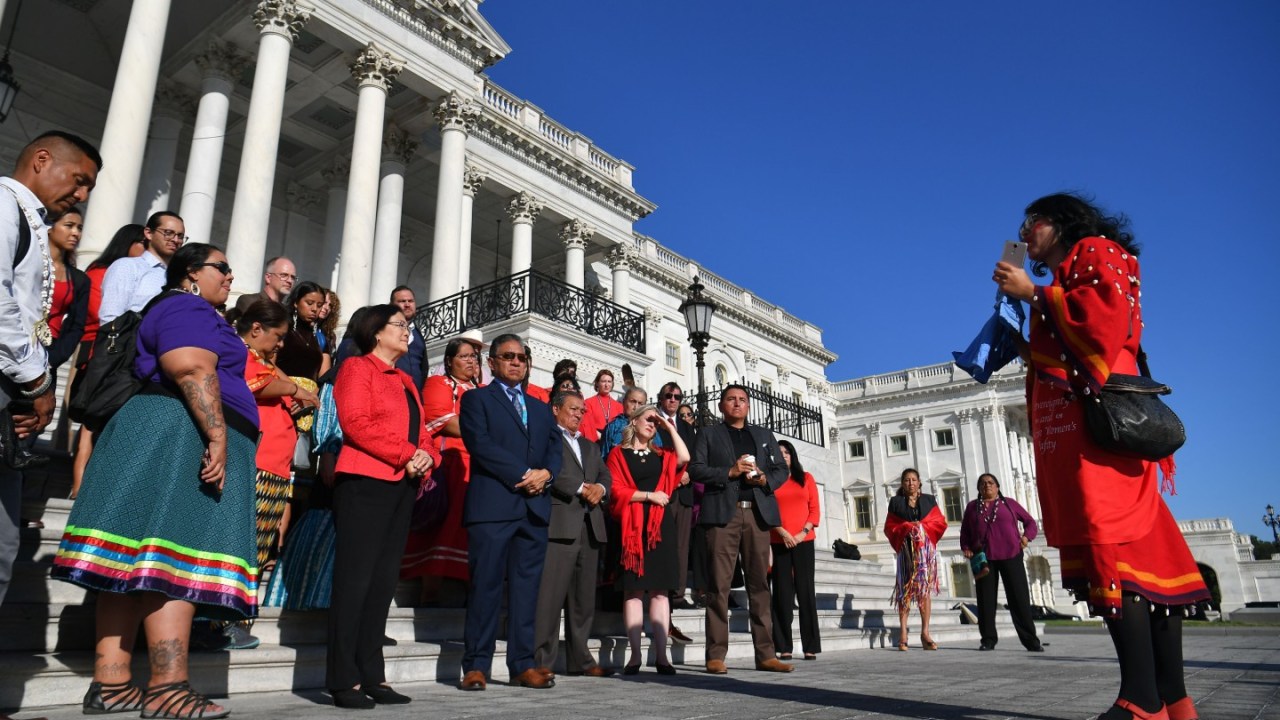 people hold a moment of silence for missing and murdered indigenous women in front of the Capitol