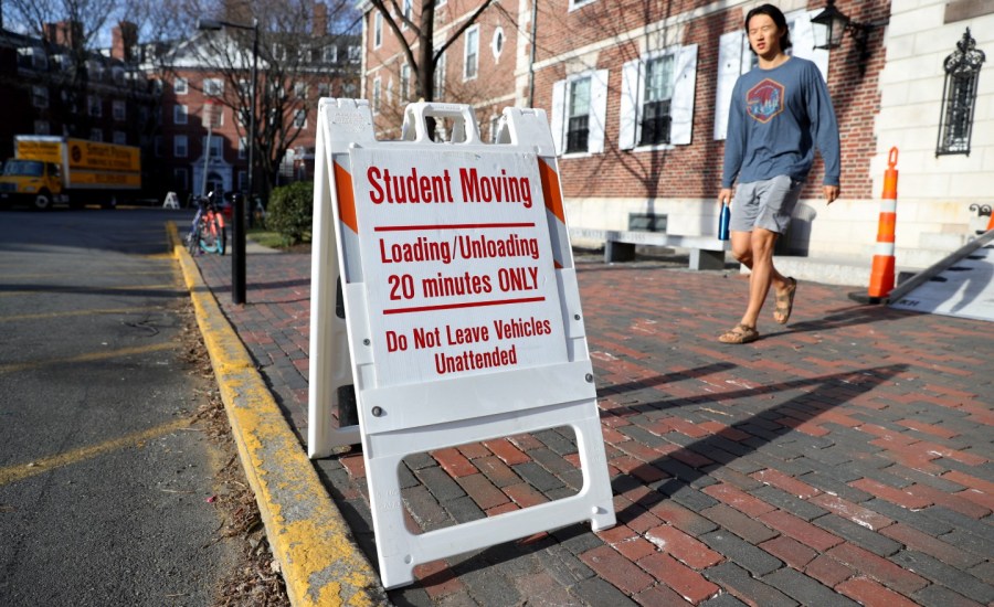 a sign designates a moving zone on the curb at harvard