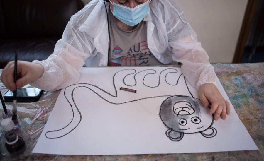 "Yago", a young autistic man hosted at the association "Elan Retrouve", dedicated to psychiatric disorders in adulthood, paints as he work with an educator