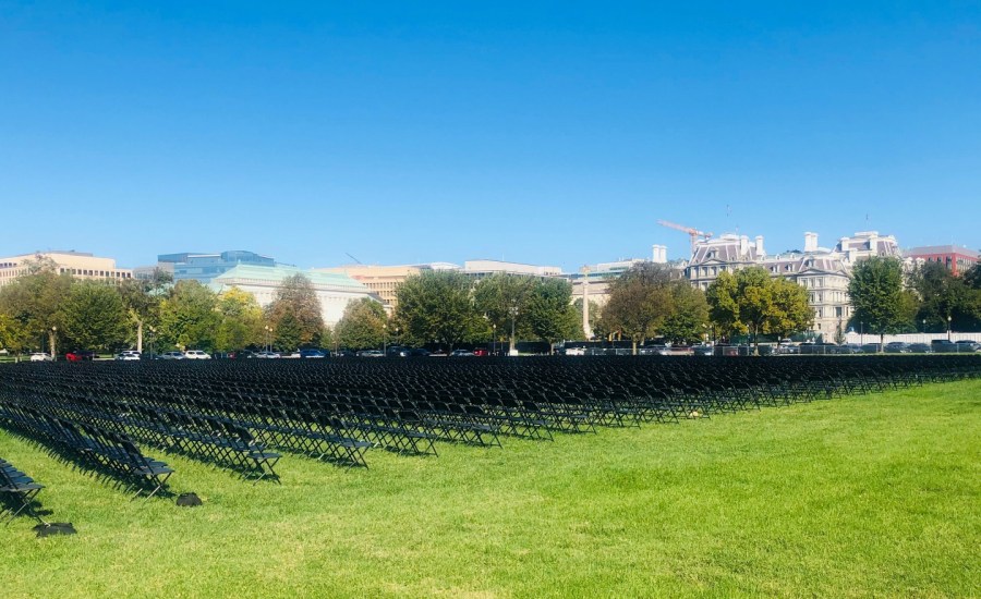 Twenty-thousand empty black chairs lined up in rows on the National Mall