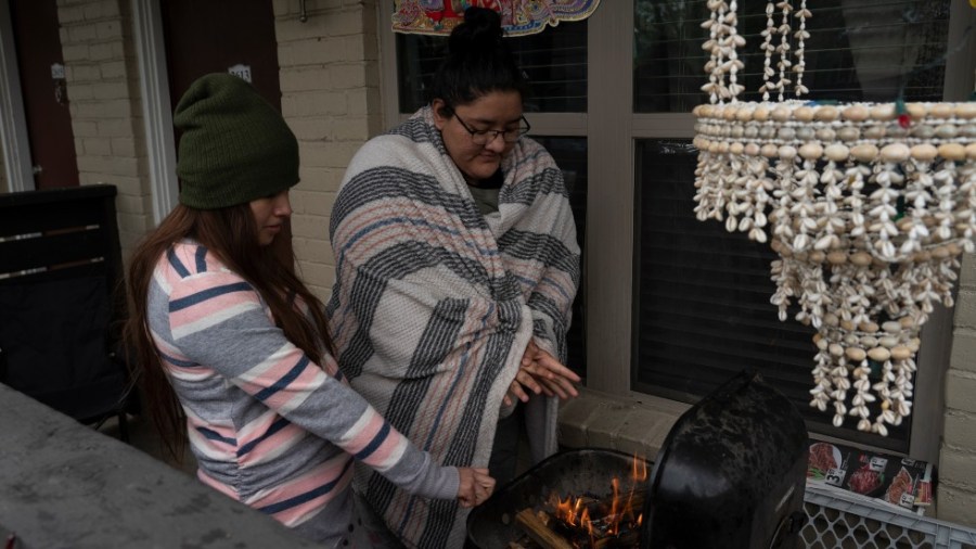 Texas residents try to stay warm using grill on porch