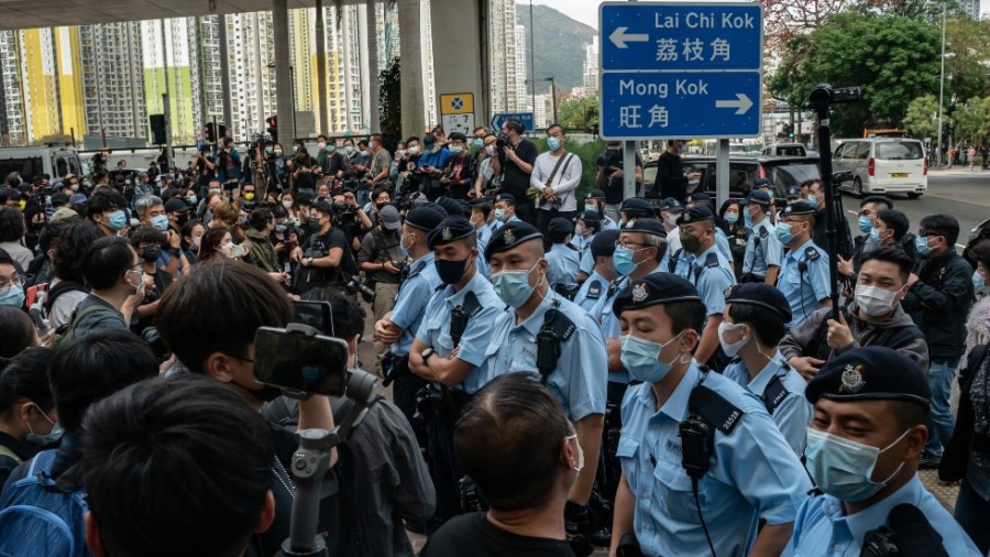 Police officers stand guard as pro-democracy supporters gather outside the West Kowloon court on March 1, 2021 in Hong Kong.