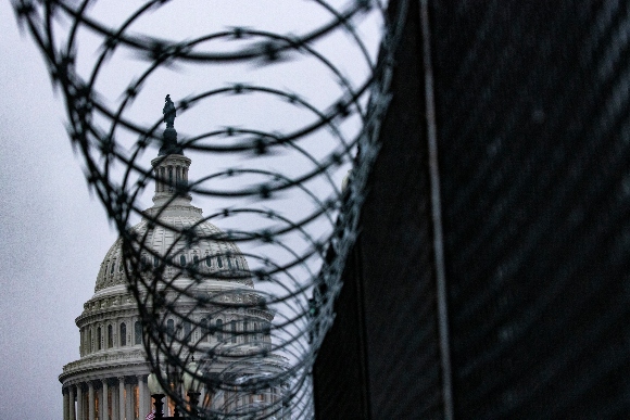 The US Capitol dome is seen past security fencing and razor wire set up around Capitol Hill.