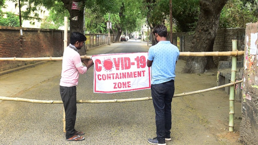 Municipal workers barricade a a contaminated zone as a preventive measure against the spread of Covid-19