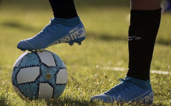 A foot is seen on a soccer ball