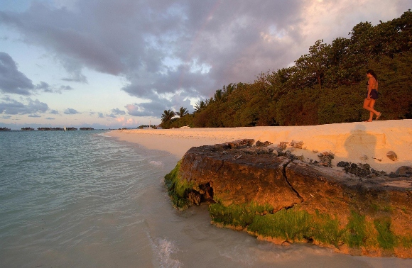 A tourist walks along the Paradise Island Resort's main beach