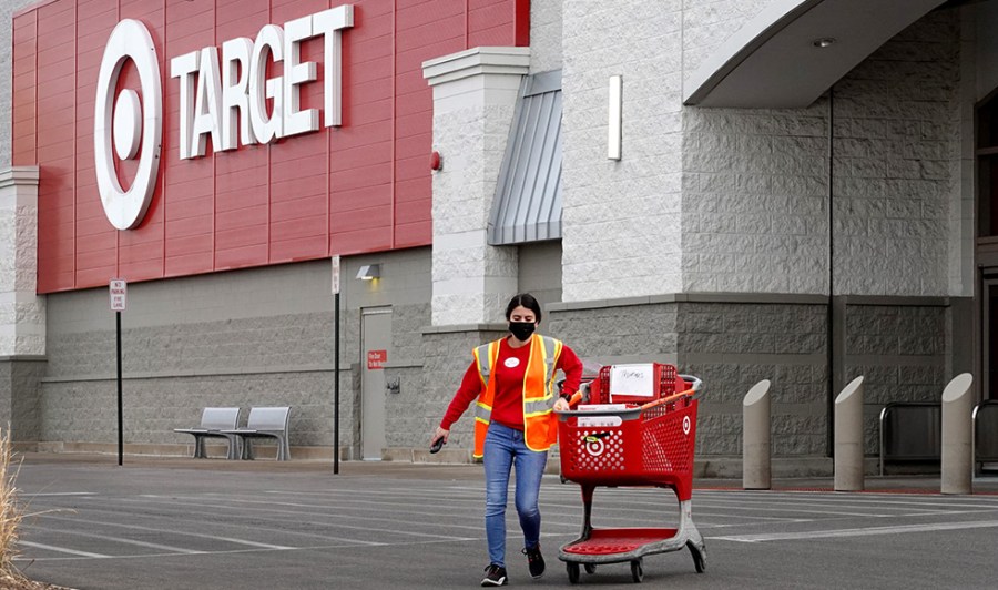 A worker brings merchandise to a customer in a Target store parking lot