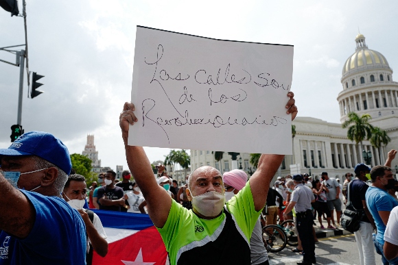 A progovernment man holds a sign during a protest against the government of Cuban President Miguel Diaz-Canel in Havana