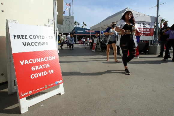  Fans walk past a COVID-19 vaccination tent before the game between the Los Angeles Dodgers and the San Francisco Giants at Dodger Stadium