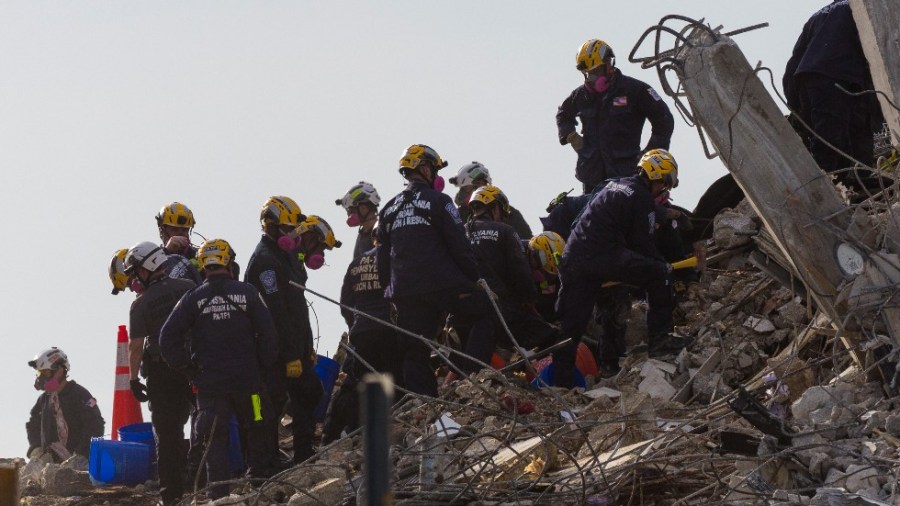 Workers prepare the partially collapsed Champlain South tower before a controlled explosion to demolish it