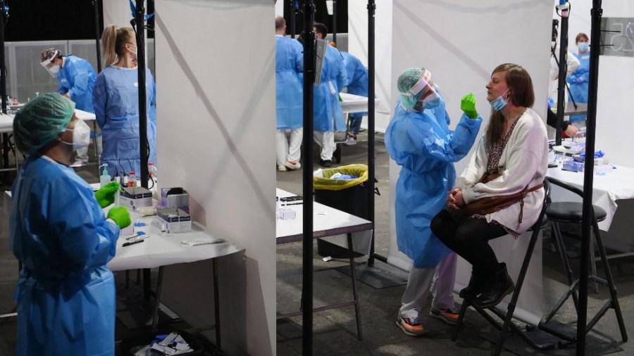 A health worker collects a swab sample for Rapid Antigen Test (RAT) for the Covid-19 coronavirus from a woman who later on March 27, 2021 will attend with other 5,000 people a rock music concert in Barcelona