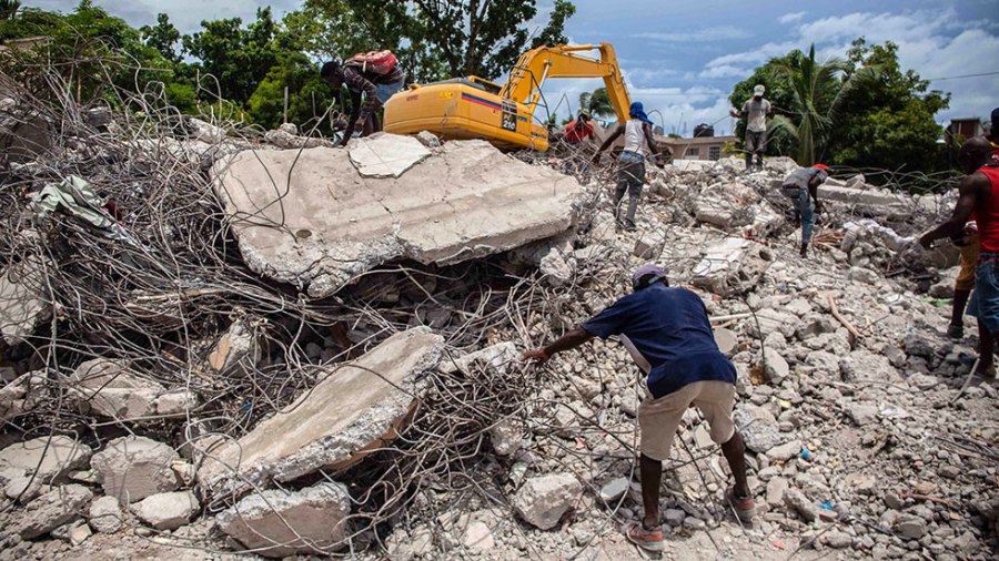 People clean up rubble with bulldozer in Haiti after earthquake