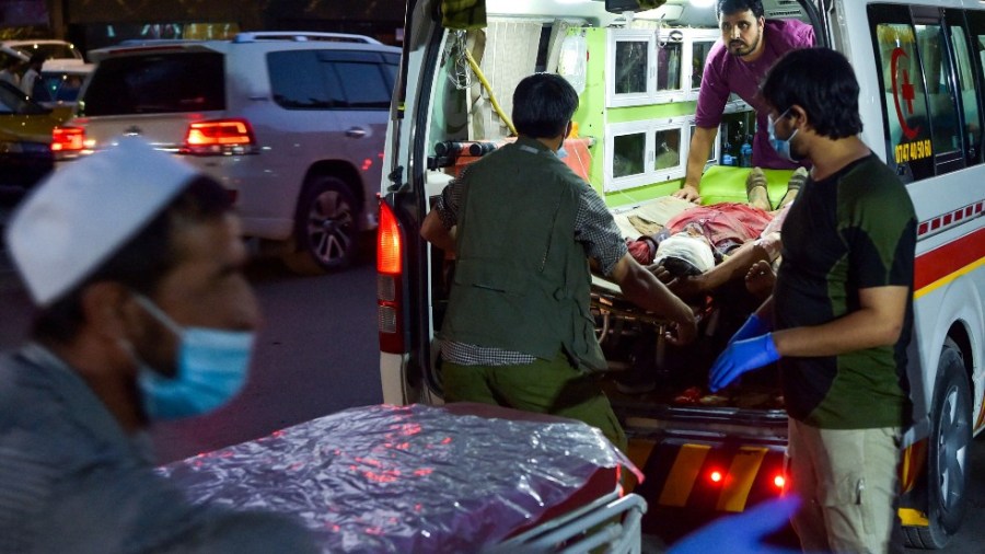 Medical staff bring an injured man to a hospital in an ambulance after two powerful explosions outside the airport in Kabul