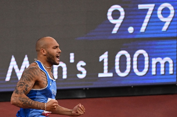 Italy's Lamont Marcell Jacobs celebrates after crossing the finish line to win the men's 100m final during the Tokyo 2020 Olympic Games