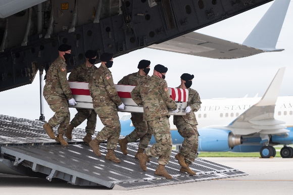 A transfer case with the remains of Army Staff Sgt. Ryan C. Knauss, 23, of Corryton, Tennessee, are carried off of a military aircraft