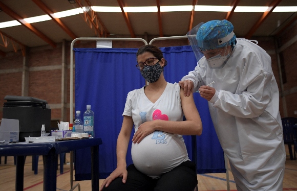 A pregnant woman receives a dose of the Pfizer-BioNTech vaccine against COVID-19