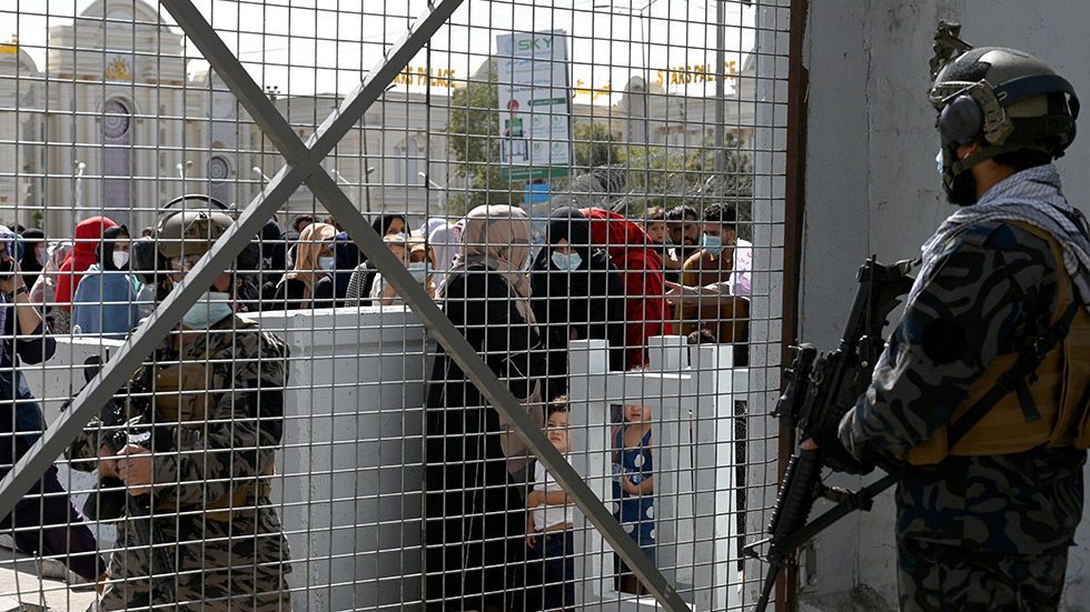 Taliban Badri fighters stand guard as Afghans wait at the main entrance gate of Kabul airport