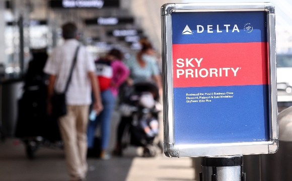 Travelers gather outside the Delta Air Lines departures level at Los Angeles International Airport