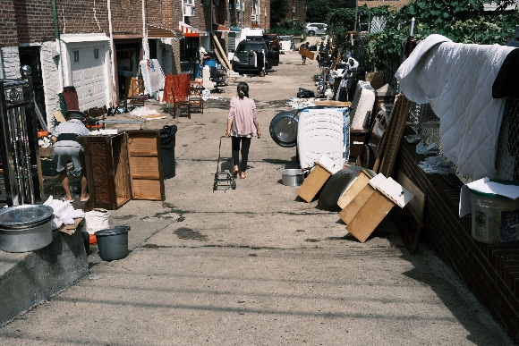 People clean up their flooded homes in a Queens neighborhood