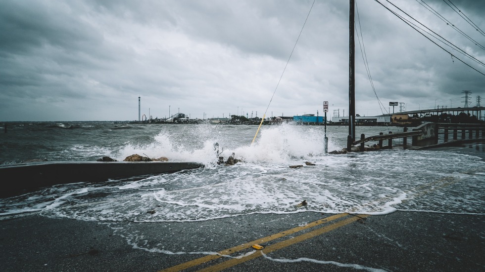 Water crashes onto a road during a hurricane