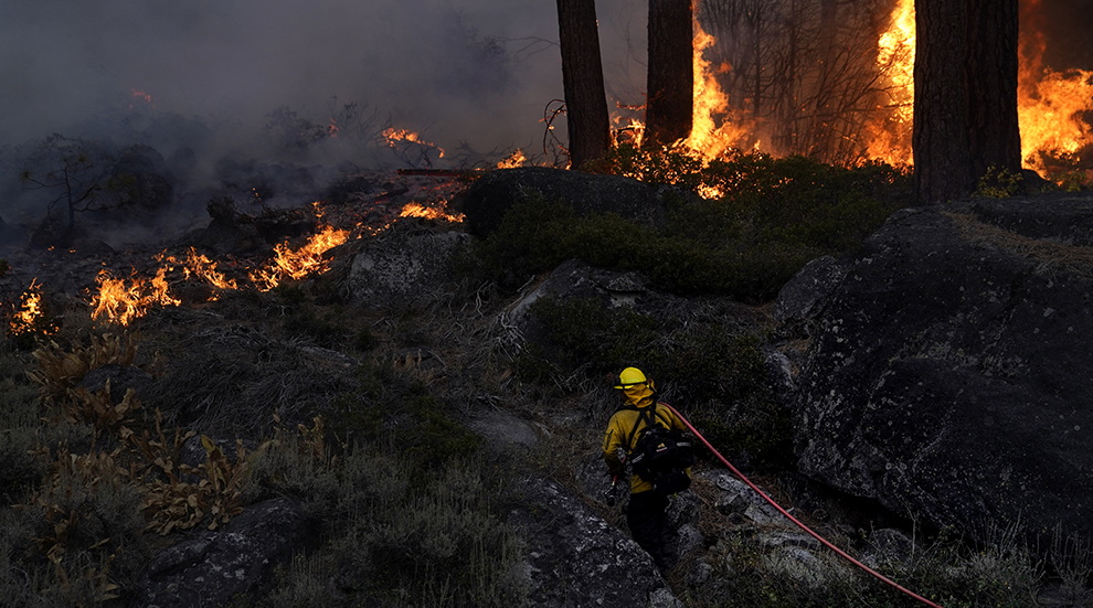 A firefighter walks toward a wildfire