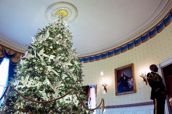 An Army White House Military social aide stands in the Blue Room of the White House during a press preview of the White House holiday decorations