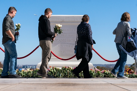 People walk to place flowers during a centennial commemoration event at the Tomb of the Unknown Soldier