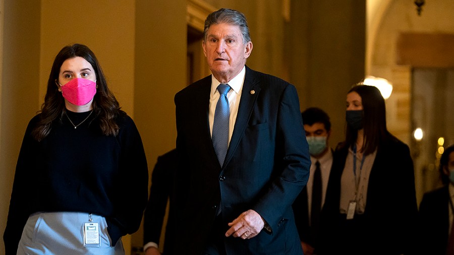 Sen. Joe Manchin (D-W.Va.) and his staff return from the Capitol Rotunda on Thursday, December 9, 2021 to pay their respects to the late Sen. Bob Dole (R-Kan.) lying in state in the Capitol Rotunda.