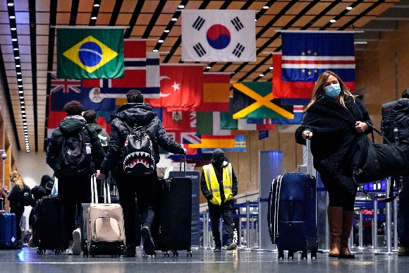 Travelers trek through Terminal E at Logan Airport