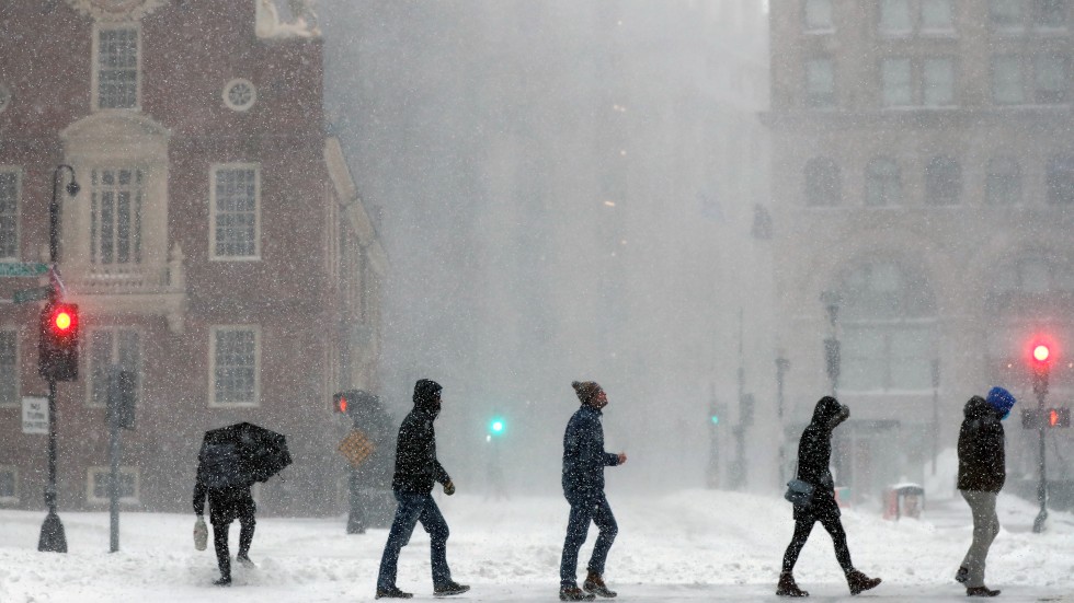 People cross Congress Street, Saturday, Jan. 29, 2022, in Boston