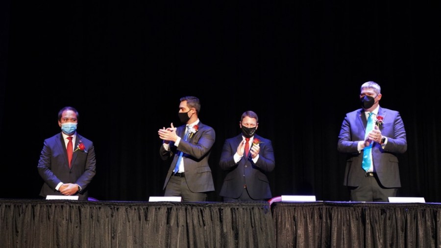 In this photo provided by Peg Shanahan, new Mayor Sokhary Chau, left, is applauded by councillors during the Lowell City Council swearing-in ceremony