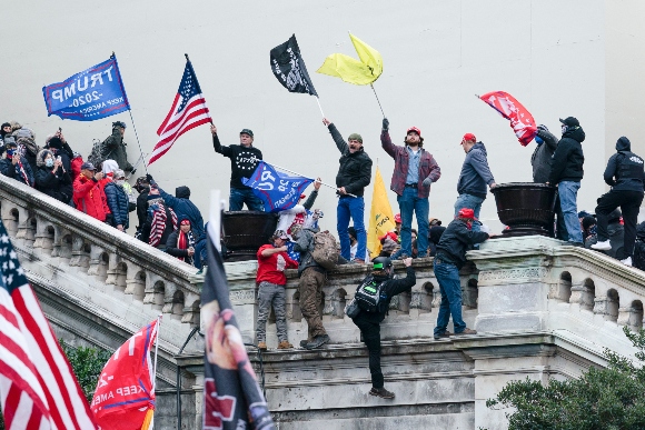 In this Jan. 6, 2021, file photo, rioters wave flags on the West Front of the U.S. Capitol