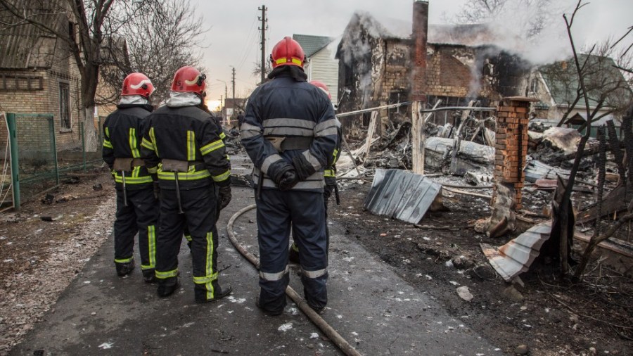 Ukrainian firefighters look at fragments of a downed aircraft seen in in Kyiv, Ukraine