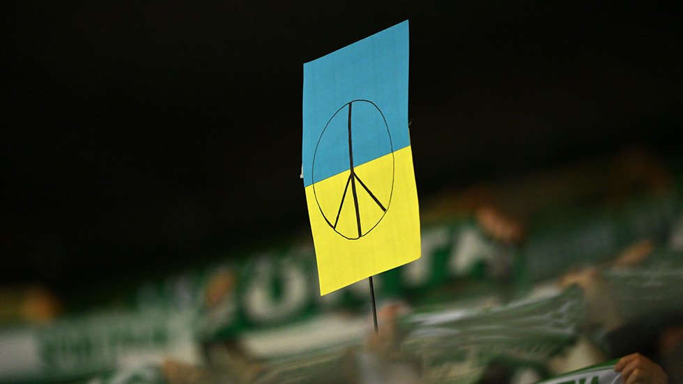 A sign the color of the Ukrainian flag with a peace symbol