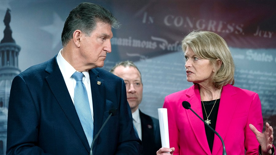 Sen. Joe Manchin (D-W.Va.) and Sen. Lisa Murkowski (R-Alaska) look at each other