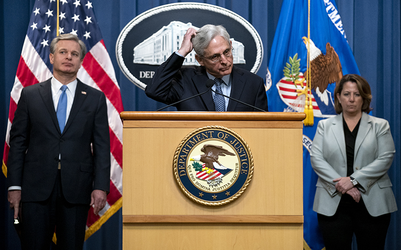 Attorney General Merrick Garland addresses reporters as he scratches his head