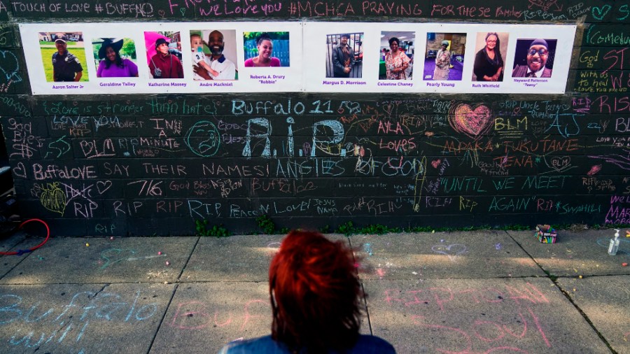 A person visits a makeshift memorial near the scene of the mass shooting at a supermarket in Buffalo, N.Y.