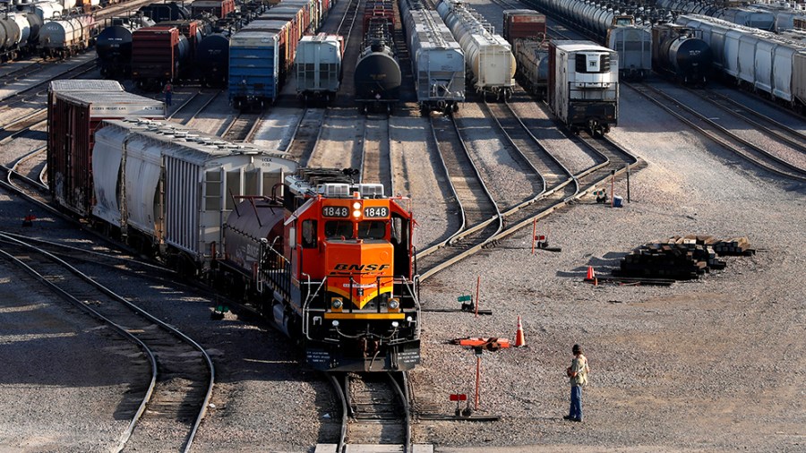 A terminal worker monitors the departure of a freight train