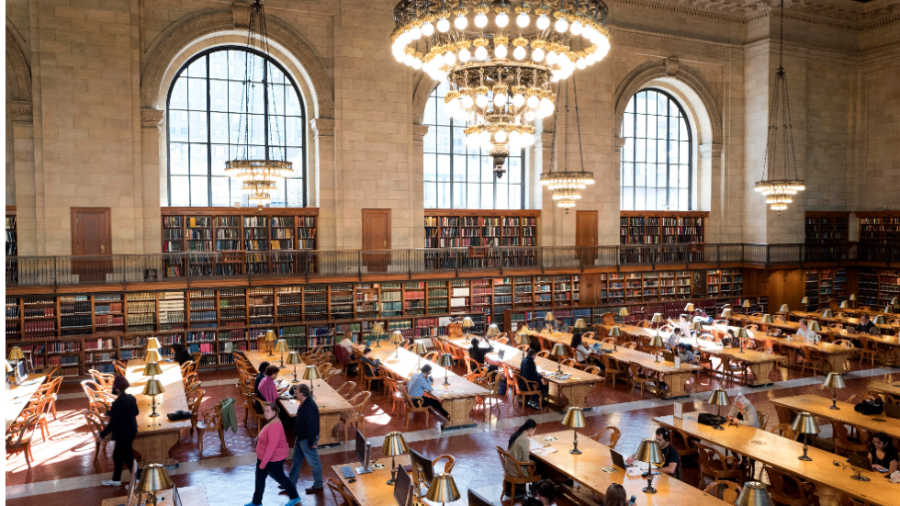 Visitors walk the main floor of a public library.