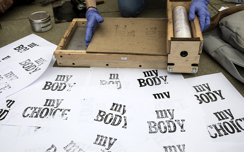 Letterpress signs that read ""My body my choice" in black ink