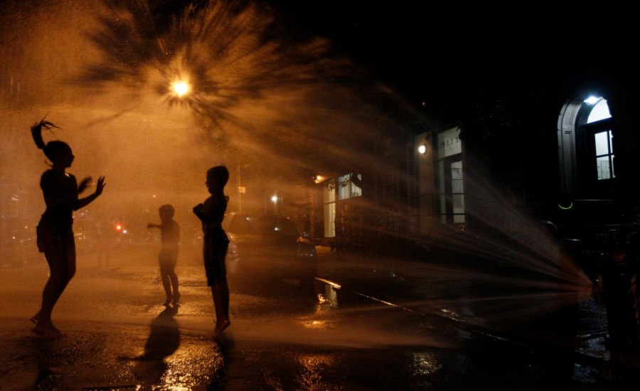 People enjoy a fountain during a heat wave.