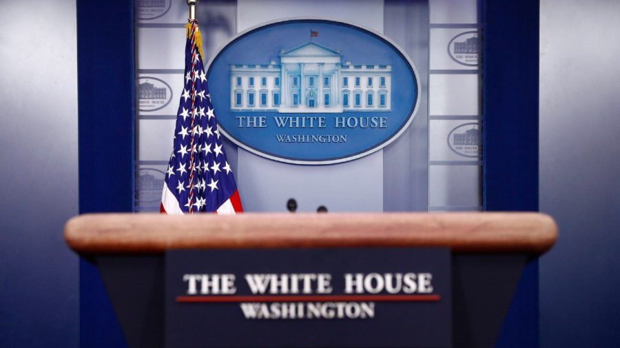 In this March 22, 2020, file photo a plaque depicting the White House is posted behind a podium in the James Brady Press Briefing Room of the White House in Washington.