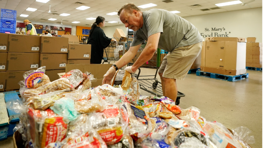 Volunteers fill up grocery carts with food for distribution into drive through vehicles at the St. Mary's Food Bank Wednesday, June 29, 2022, in Phoenix.