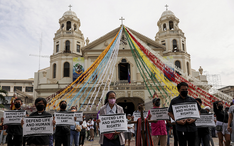 Activists hold placards against the inauguration ceremony of the Philippines' president-elect