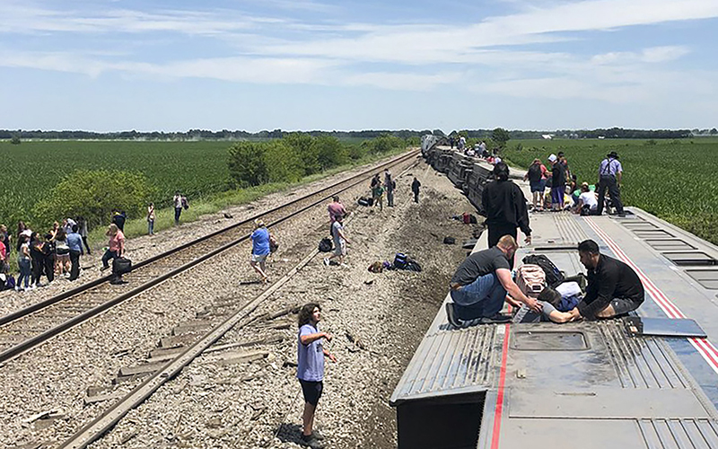 An Amtrak passenger train lies on its side after derailing