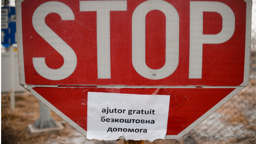 A poster with a text that reads "Free Help" is glued to a Stop sign at the Romanian-Ukrainian border, in Siret, Romania, Monday, March 7, 2022.