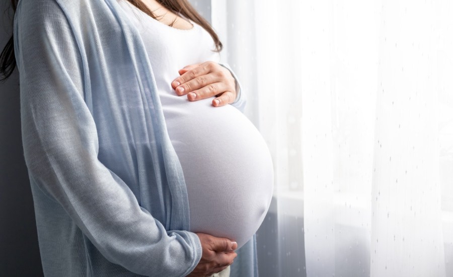 Pregnant woman holding stomach.