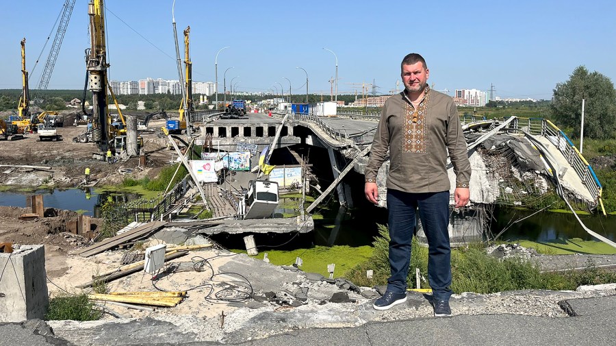 Mayor Oleksandr Marukshin stands in front of Irpin's destroyed bridge. 