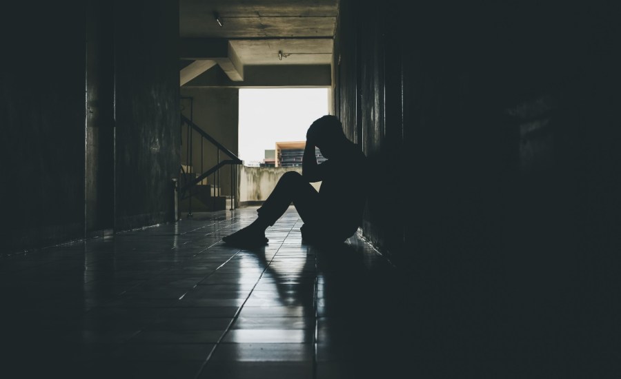 Teen sitting in hallway.