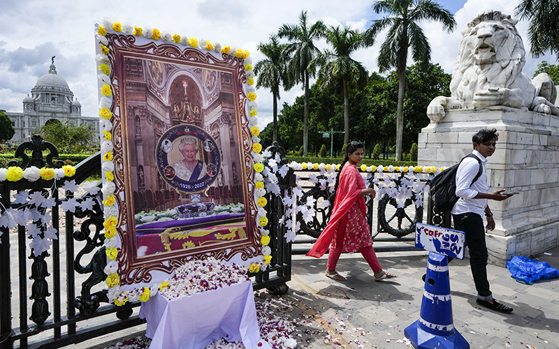 Visitors walk past a portrait of Britain's Queen Elizabeth II